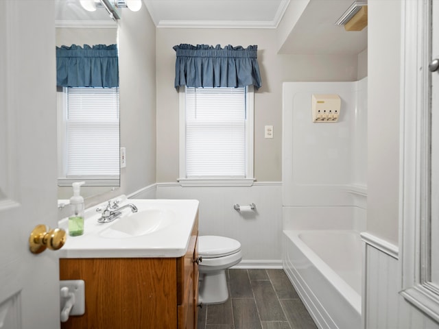 bathroom featuring wood finish floors, crown molding, toilet, wainscoting, and vanity