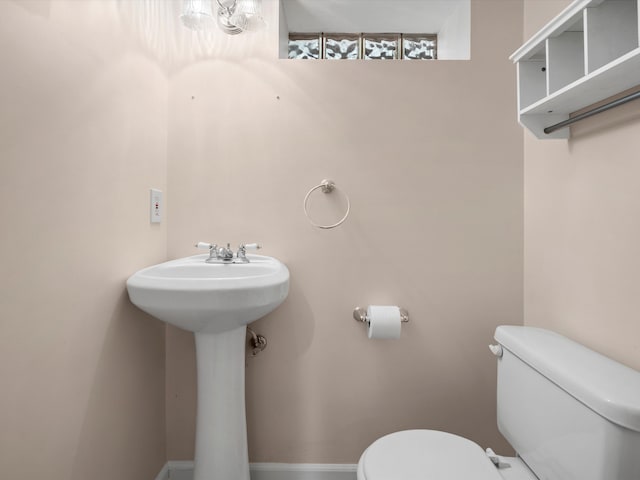 bathroom with toilet and baseboards