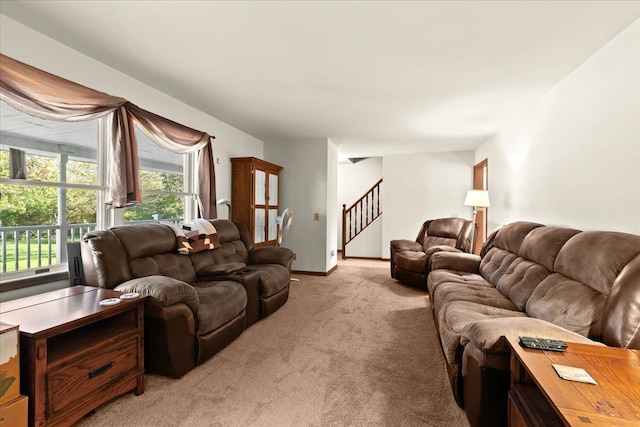 living room with light colored carpet, stairway, and baseboards