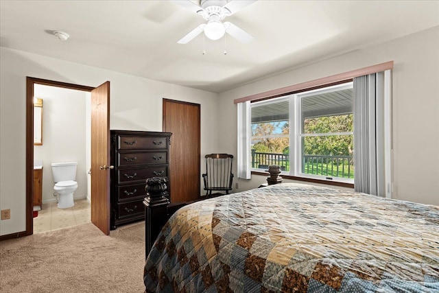 bedroom with ensuite bathroom, baseboards, and light colored carpet