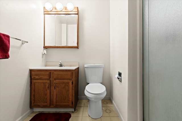 half bath featuring tile patterned floors, vanity, toilet, and baseboards