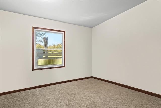 unfurnished room with carpet flooring and baseboards