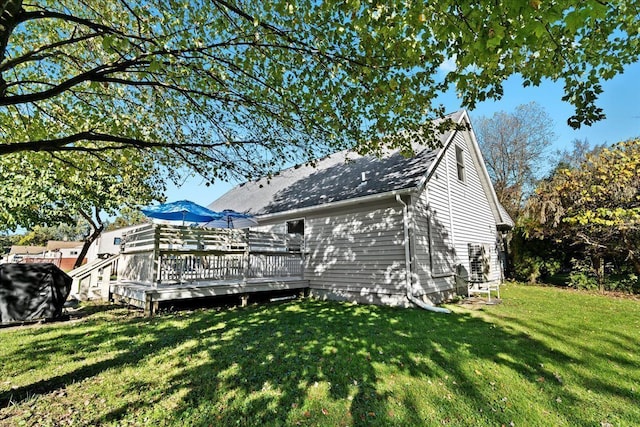 rear view of house with a lawn and a wooden deck