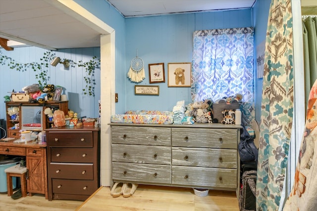 bedroom featuring wood finished floors and wooden walls