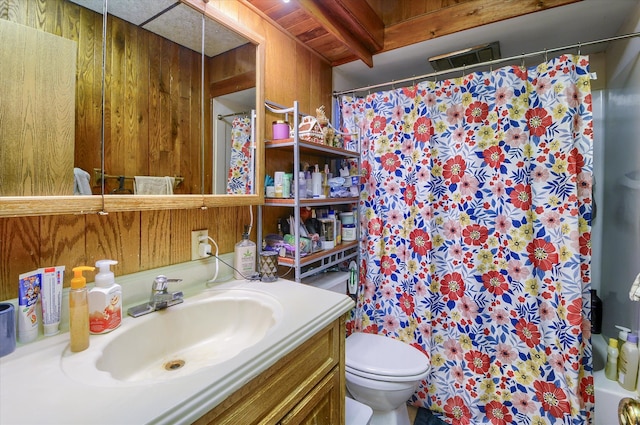 full bathroom featuring toilet, wood walls, visible vents, and vanity