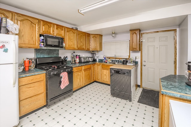 kitchen with a sink, black appliances, brown cabinetry, and light floors