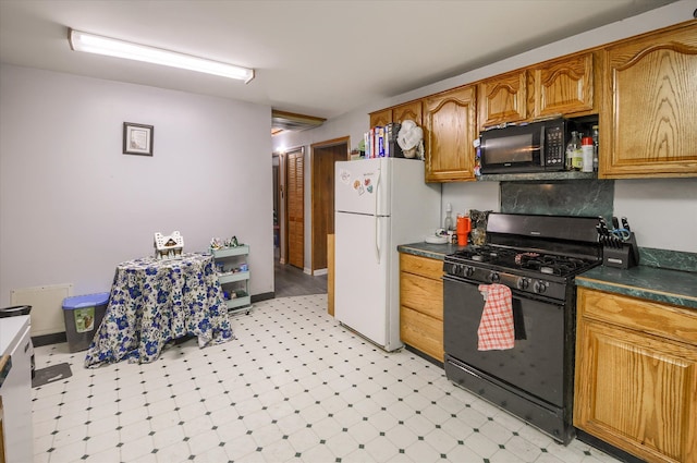 kitchen featuring black appliances, light floors, dark countertops, and brown cabinetry