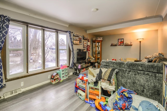 playroom featuring wood finished floors, visible vents, and baseboards