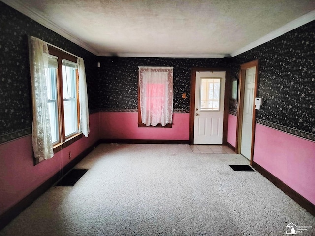 interior space featuring light carpet, visible vents, baseboards, ornamental molding, and wallpapered walls