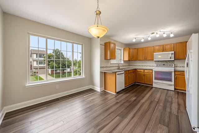 kitchen with white appliances, tasteful backsplash, dark wood-type flooring, and a sink