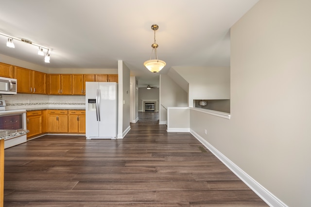 kitchen with white appliances, dark wood-style flooring, light countertops, hanging light fixtures, and tasteful backsplash