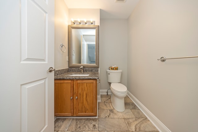 half bathroom with toilet, visible vents, baseboards, and vanity