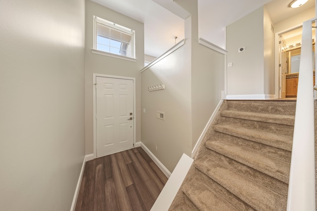 stairway with wood finished floors and baseboards