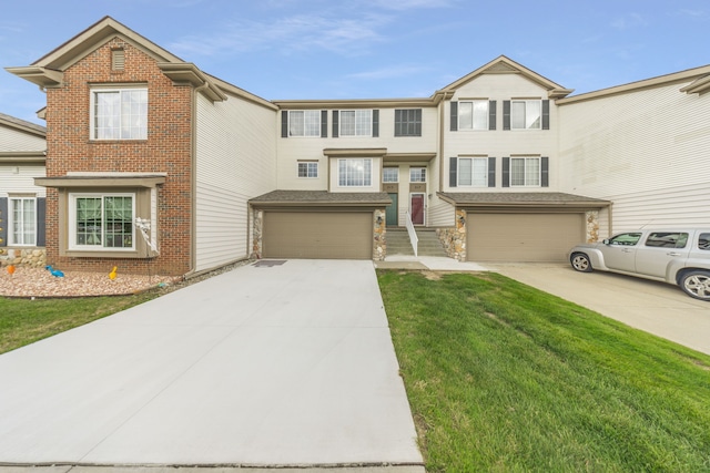 view of front of property featuring a garage, a front yard, stone siding, and driveway