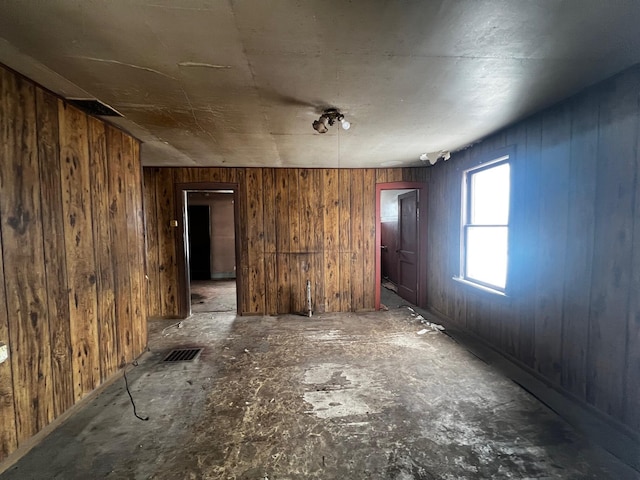 empty room with visible vents and wooden walls