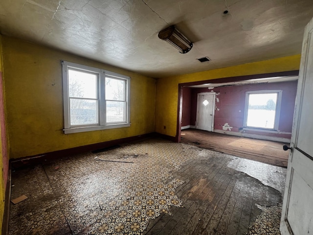 interior space with hardwood / wood-style floors, visible vents, and baseboards