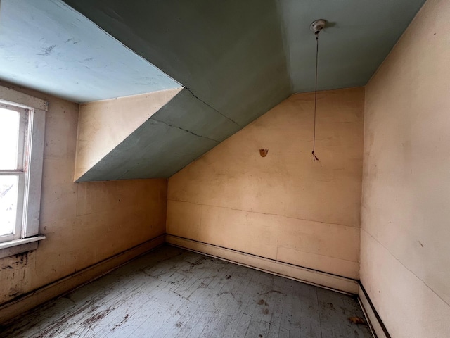 additional living space featuring lofted ceiling and wood-type flooring