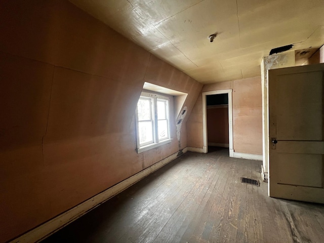 bonus room featuring hardwood / wood-style floors, visible vents, and baseboards