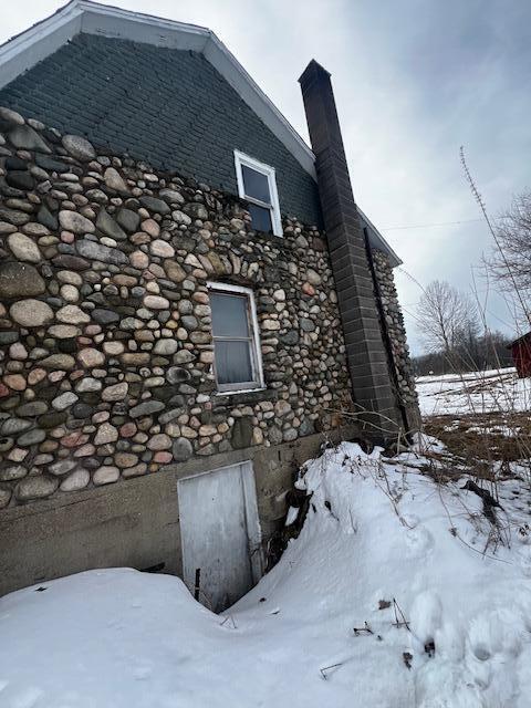 view of snowy exterior with a chimney