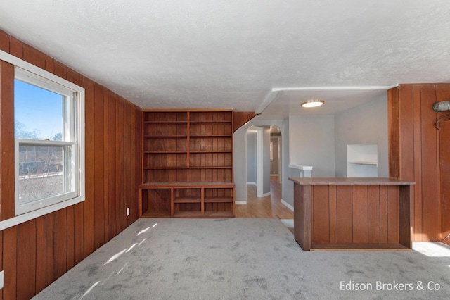 interior space featuring built in features, wood walls, arched walkways, and a textured ceiling