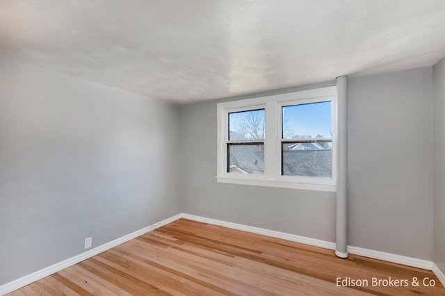 empty room with light wood-type flooring and baseboards