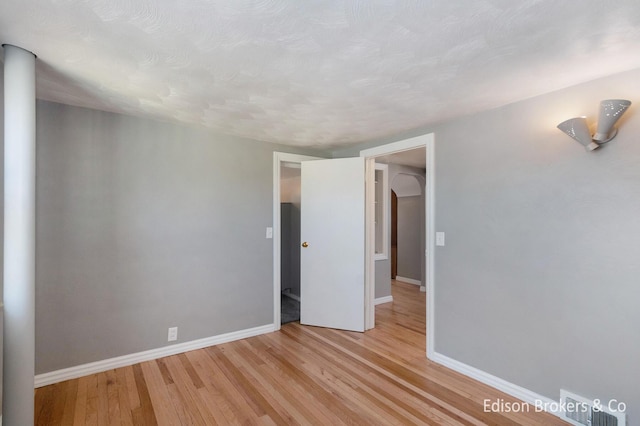 unfurnished bedroom with light wood-style flooring and baseboards