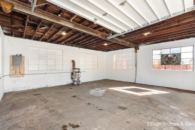 basement with a garage, electric panel, and concrete block wall