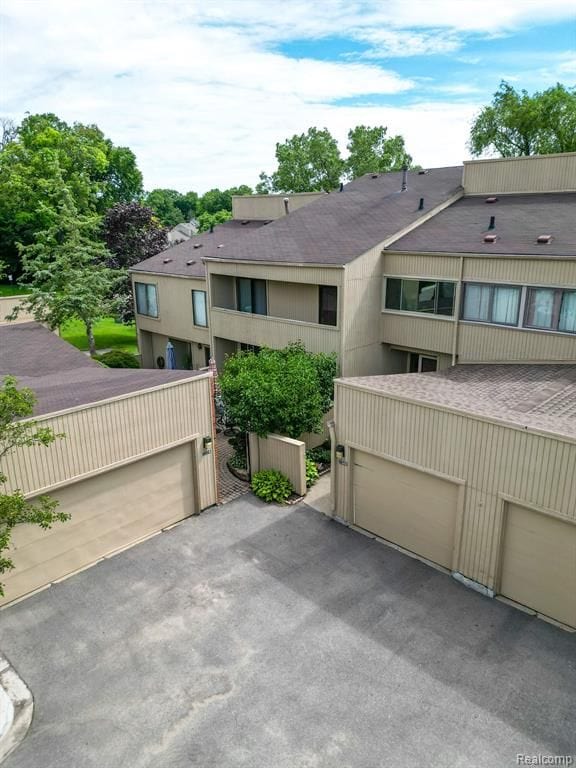 view of front of property featuring a garage and a shingled roof