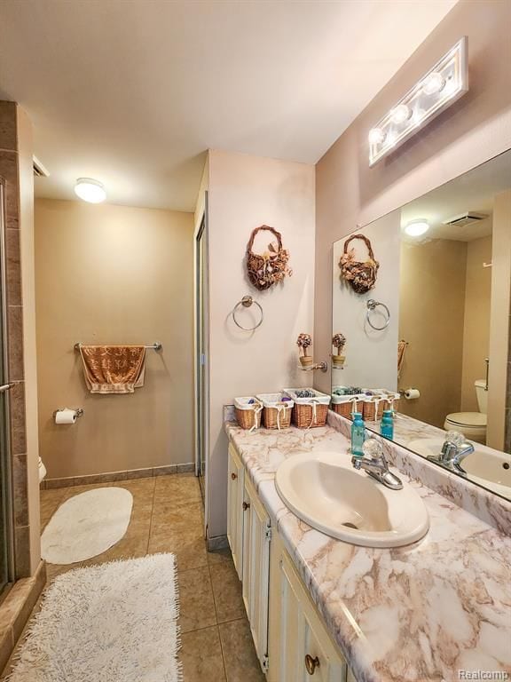 bathroom with baseboards, visible vents, toilet, tile patterned floors, and vanity