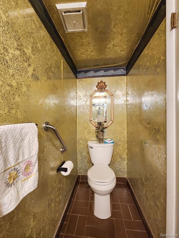 bathroom with toilet, baseboards, and visible vents