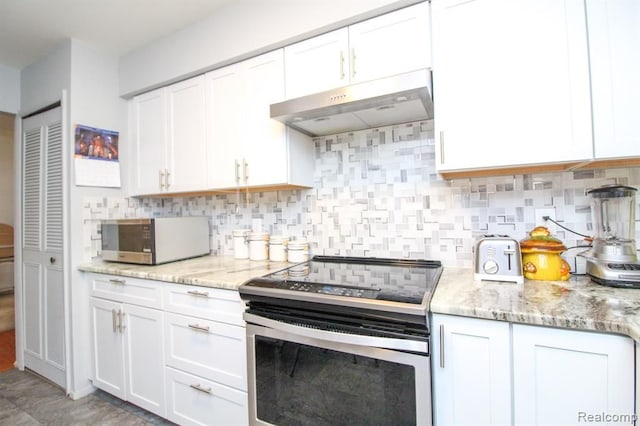 kitchen with white cabinets, decorative backsplash, light stone counters, stainless steel appliances, and under cabinet range hood