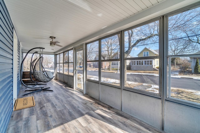 unfurnished sunroom featuring a ceiling fan