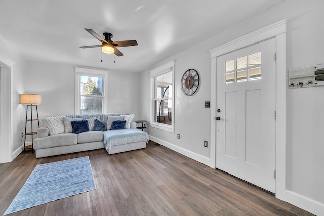 living room featuring baseboards, wood finished floors, and a healthy amount of sunlight