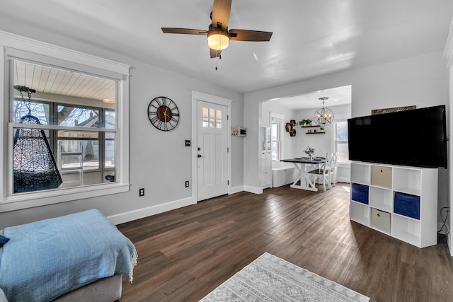 foyer entrance with dark wood finished floors, a ceiling fan, and baseboards