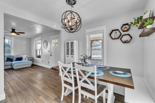 dining room with a chandelier, baseboards, and wood finished floors