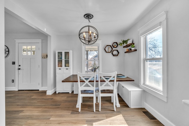 dining room with breakfast area, plenty of natural light, wood finished floors, and visible vents