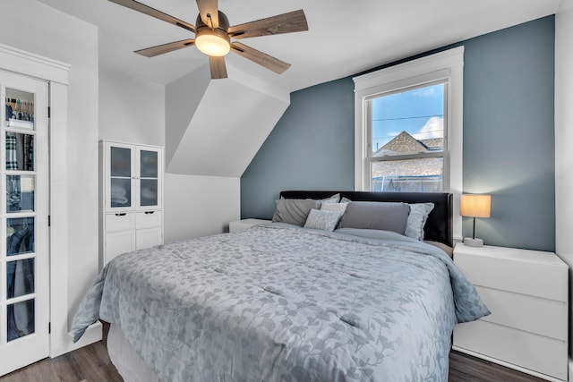 bedroom with a ceiling fan, vaulted ceiling, and dark wood-style flooring