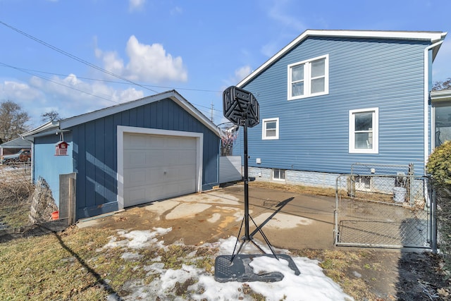 view of side of property with a garage, an outbuilding, and concrete driveway