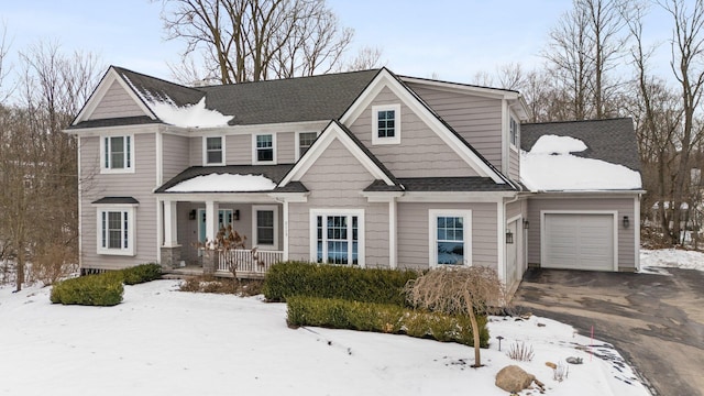 view of front of house with a garage, driveway, a porch, and a shingled roof