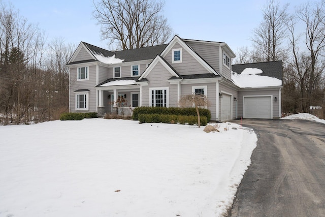 view of front of property with a garage, aphalt driveway, and covered porch