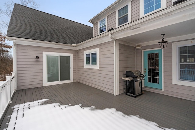 snow covered deck with a grill