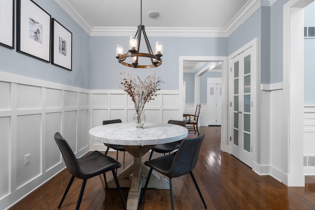 dining room featuring dark wood-style floors, crown molding, visible vents, a decorative wall, and an inviting chandelier