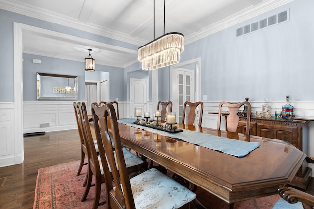 dining room with dark wood-style floors, wainscoting, visible vents, and a chandelier