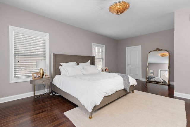 bedroom with dark wood-style floors and baseboards