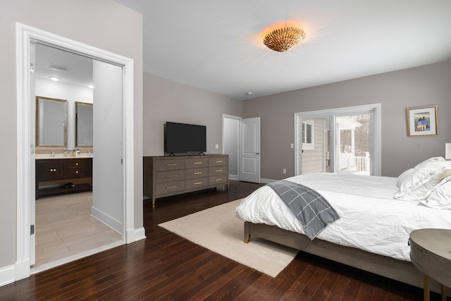 bedroom with dark wood-style flooring, connected bathroom, and baseboards