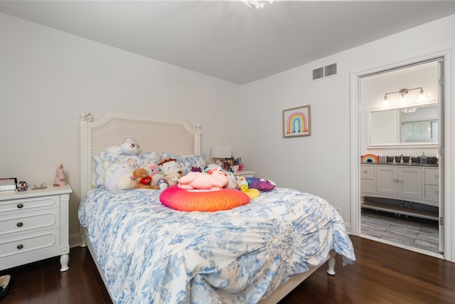 bedroom with ensuite bath, visible vents, and dark wood finished floors