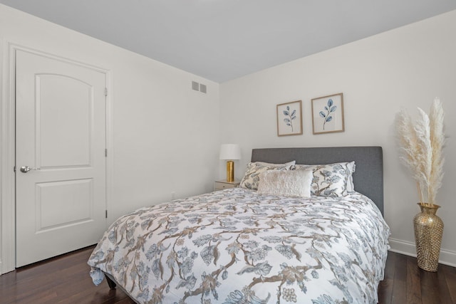 bedroom featuring dark wood-style floors, visible vents, and baseboards