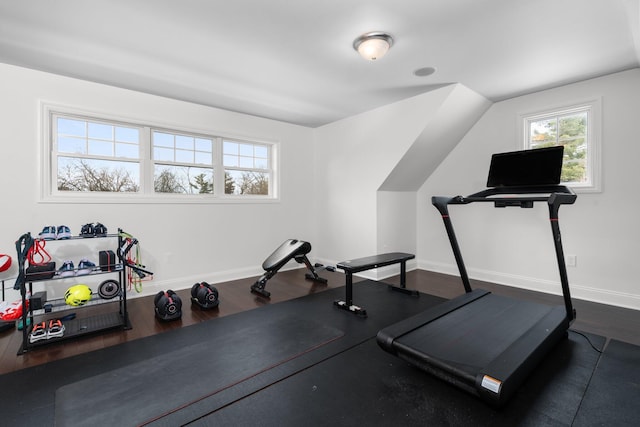 exercise area with lofted ceiling, baseboards, and wood finished floors