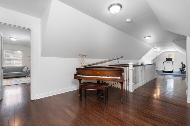 living area with dark wood-style floors, lofted ceiling, an upstairs landing, and baseboards