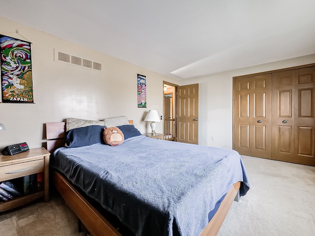 bedroom with a closet, visible vents, and light carpet